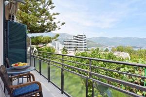 un balcón con una mesa y un bol de fruta. en Apartments Ivanovic, en Budva