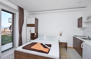 Un dormitorio con una cama grande y una ventana en Apartments Ivanovic, en Budva