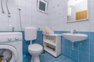 a bathroom with a washing machine and a sink at Apartment Studenka in Makarska