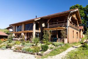 a wooden house with a garden in front of it at Graine de Tilia in Saint-Antoine