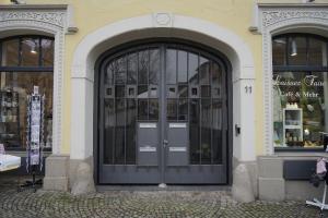eine schwarze Tür in einem Gebäude mit zwei Fenstern in der Unterkunft Pfalzkind - Ein Stück Heimat im Alltag in Bad Dürkheim