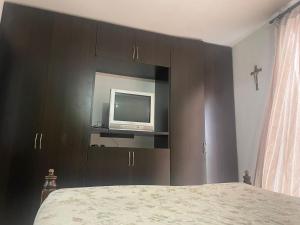 - une chambre avec un lit et une télévision sur une armoire dans l'établissement Casa Familiar Pereira Manzana, à Pereira