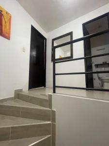 a stairway with a black door and a window at Casa Familiar Pereira Manzana in Pereira