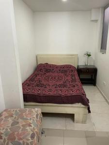 a bedroom with a bed with a red blanket on it at Casa Familiar Pereira Manzana in Pereira