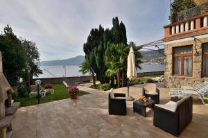 eine Terrasse mit Stühlen, einem Sonnenschirm und einem Tisch in der Unterkunft Apartments Romina in Rijeka