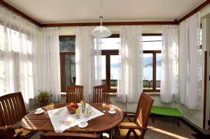 a dining room with a table and chairs and windows at Apartments Romina in Rijeka