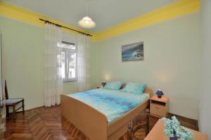 a bedroom with a bed and a table and a window at Apartments Romina in Rijeka