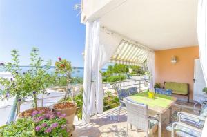 um pátio com uma mesa e cadeiras e vista para o oceano em Apartments Nives em Trogir