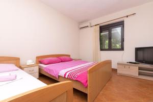 a bedroom with two beds and a flat screen tv at Apartments Aleksandar in Ulcinj