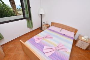 a bed with pink bows on it in a room at Apartments Aleksandar in Ulcinj