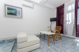 sala de estar con mesa y silla en Apartment and Rooms Ivan, en Makarska