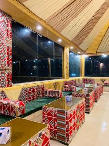 a restaurant with red and white chairs and tables at sand magic camp in Wadi Rum