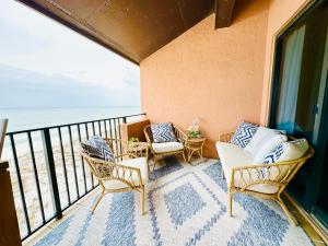 a balcony with chairs and a view of the ocean at Gulf Front Penthouse Condo in Pensacola Beach
