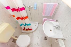 a bathroom with a toilet and a shower curtain at Apartments Kazimir in Nečujam
