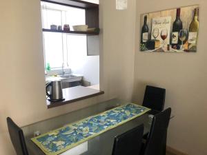 a kitchen with a table with chairs and a window at DEPARTAMENTO EN LA SERENA in La Serena