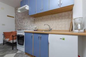 una cocina con armarios azules y fregadero en Apartments Anita, en Slatine
