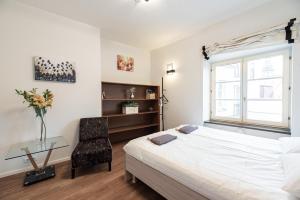 a bedroom with a bed and a chair and a window at AirHome - Raekoja Plats in Tallinn