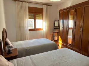 a hotel room with two beds and a window at EL COTARRO DE PESQUERA in Pesquera de Duero