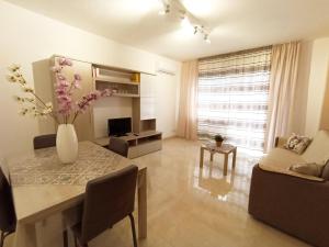 - un salon avec une table et un vase de fleurs dans l'établissement Marisol Apartment, à Altavilla Milicia