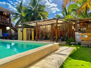 ein Swimmingpool vor einem Haus mit Palmen in der Unterkunft Cabañas Frida in Chelem