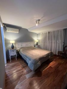 a bedroom with a bed and two tables and two lamps at Recoleta Posada in Buenos Aires
