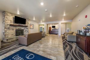 een lobby met banken en een open haard bij Cobblestone Hotel & Suites - Hutchinson in Hutchinson