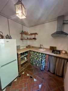 La cuisine est équipée d'un réfrigérateur blanc et d'un évier. dans l'établissement El puente de lata 1, à Dúrcal