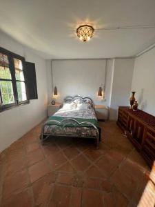 - une chambre avec un lit, deux tables et une lampe dans l'établissement El puente de lata 1, à Dúrcal