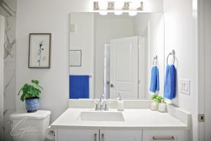 エドモントンにあるChic Modern Home,King Bed,Fireplace,Disneyの洗面台と鏡のある白いバスルーム +55枚の写真