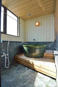 a bathroom with a green tub and a sink at Juyoh Hotel in Tokyo