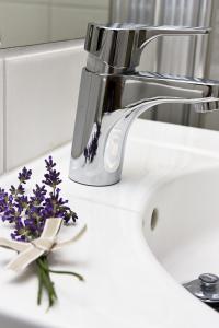 a sink with a faucet and purple flowers on it at Sahlströmsgården in Torsby