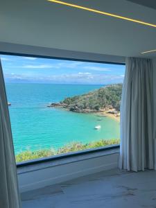 a window with a view of the ocean at Colonna Park Hotel in Búzios