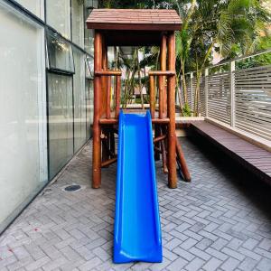 a playground with a blue slide and a wooden structure at Mediterrâneo 507 - Todo Equipado, Ar Condicionado, Churrasqueira na Varanda, Internet Fibra 600MB, Estacionamento Grátis in Cabo Frio