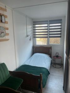 ein kleines Schlafzimmer mit einem Bett und einem Fenster in der Unterkunft Het Hongaarse Vissershuisje in Dunaszekcső