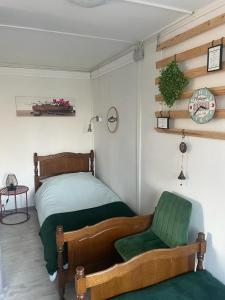 ein Schlafzimmer mit einem Bett und einem grünen Stuhl in der Unterkunft Het Hongaarse Vissershuisje in Dunaszekcső