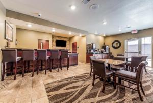 um bar numa sala com cadeiras e uma cozinha em Cobblestone Hotel & Suites - Hutchinson em Hutchinson