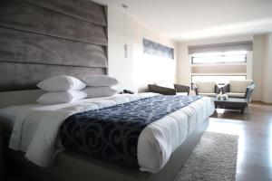 een slaapkamer met een groot bed en een bank bij Hotel Posada Tulancingo in Tulancingo