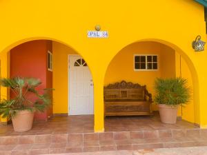 a yellow building with a bed in the middle at Casa Opal in Palm-Eagle Beach