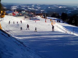 a group of people skiing down a snow covered slope at Wald-Panorama-Zimmer in Mönichkirchen
