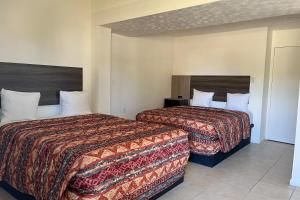 two beds in a hotel room with two beds at Captain's Table Hotel by Everglades Adventures in Everglades City