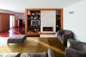 a living room with a couch and a tv at Seven Books House in Carrazeda de Anciães