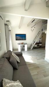 a living room with a couch and a staircase at Bel appartement 300m plage Nartelle in Sainte-Maxime