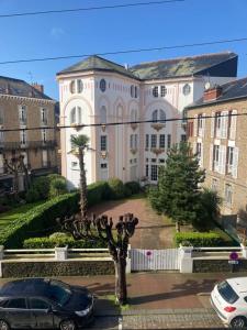 a large building with cars parked in front of it at 27 boulevard Féart in Dinard