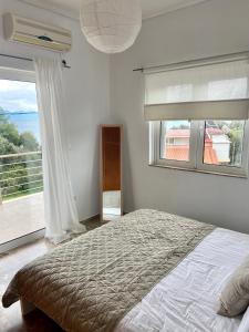 1 dormitorio con cama y ventana grande en Villa Delfini, en Chrani
