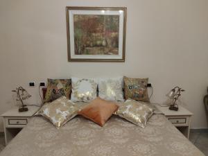 a bed with pillows and a picture on the wall at Hotel Sanremo in Sanremo