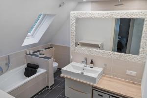 a bathroom with a sink and a toilet and a mirror at Modernes 3-Zimmer Loft Eslohe Hennesee 5 min in Eslohe