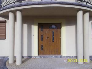 a wooden door on a building with columns at Apartamenty by Hanna in Łeba