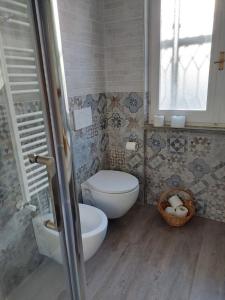 baño con aseo y lavabo y ventana en Ca Da Edda en Calice Ligure