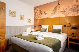 une chambre d'hôtel avec un grand lit et des serviettes. dans l'établissement Hotel Jacobs, à Bruges