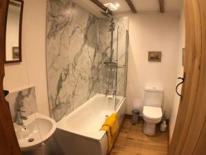 a bathroom with a tub and a sink and a toilet at ryton grange church barn sleeps 5 in Shrewsbury